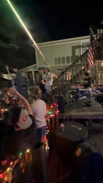 The Fretters playing a string-lit backyard show at night