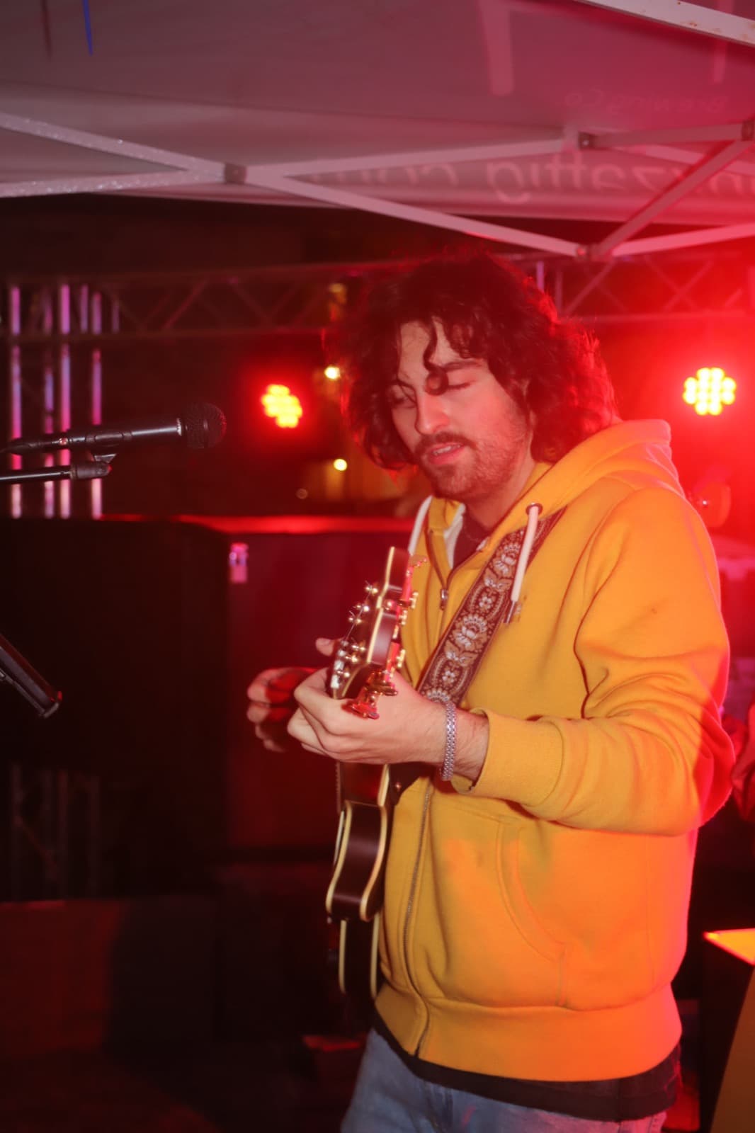 The Fretters guitarist in a yellow hoodie, deep in it