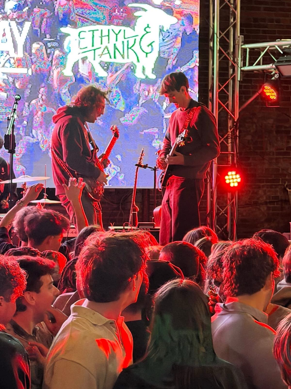 The Fretters onstage over a shoulder-to-shoulder crowd