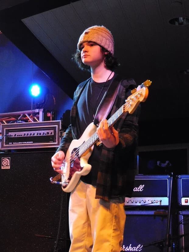 PsychoFuzz bassist mid-song under blue stage light